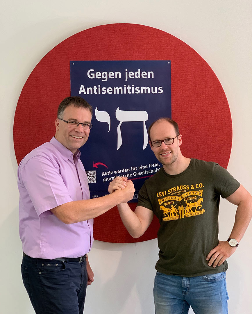 H. Führer und F. Bagus vor dem neugestaltetem Plakat